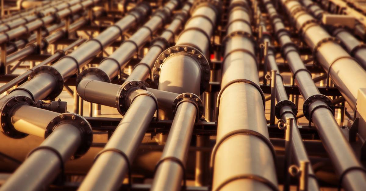 An elaborate system of pipes for an oil pipeline is shown. The pipes are gray and raised up on brackets.